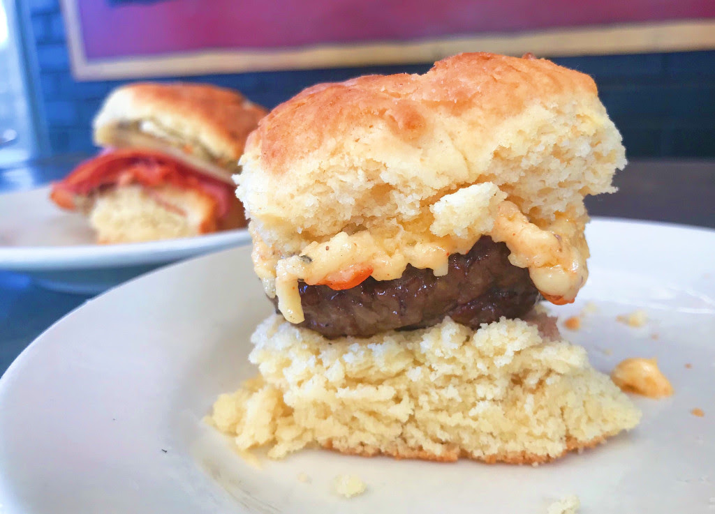 A pimento cheeseburger slider on a biscuit.