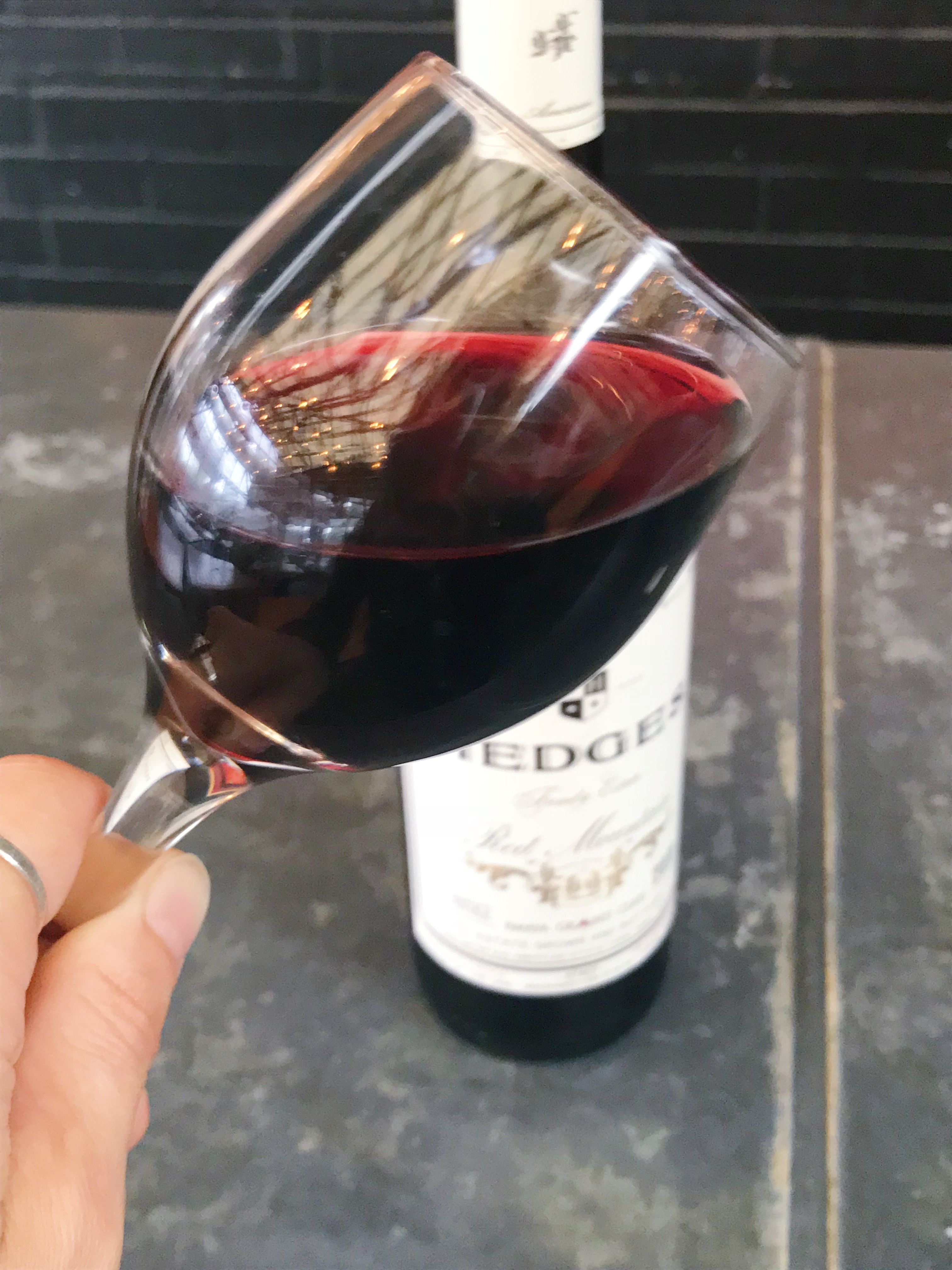 A bottle and a glass of the Hedges Family Estate Red Mountain Cabernet Blend.
