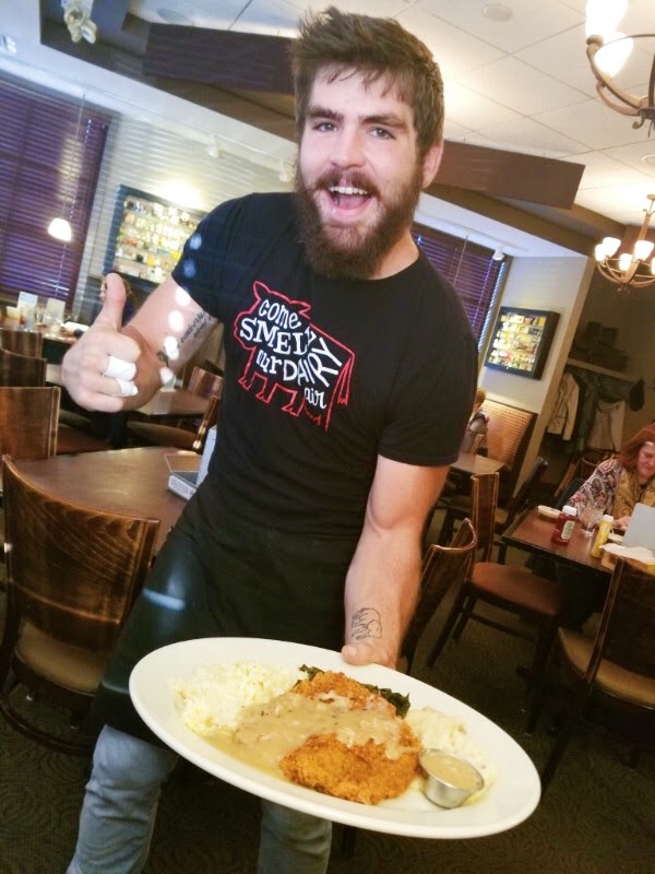 Roadhouse server, Michael Smith, holding a plate of chicken fried steak.