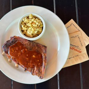 Half a rack of ribs smothered in red bbq sauce.