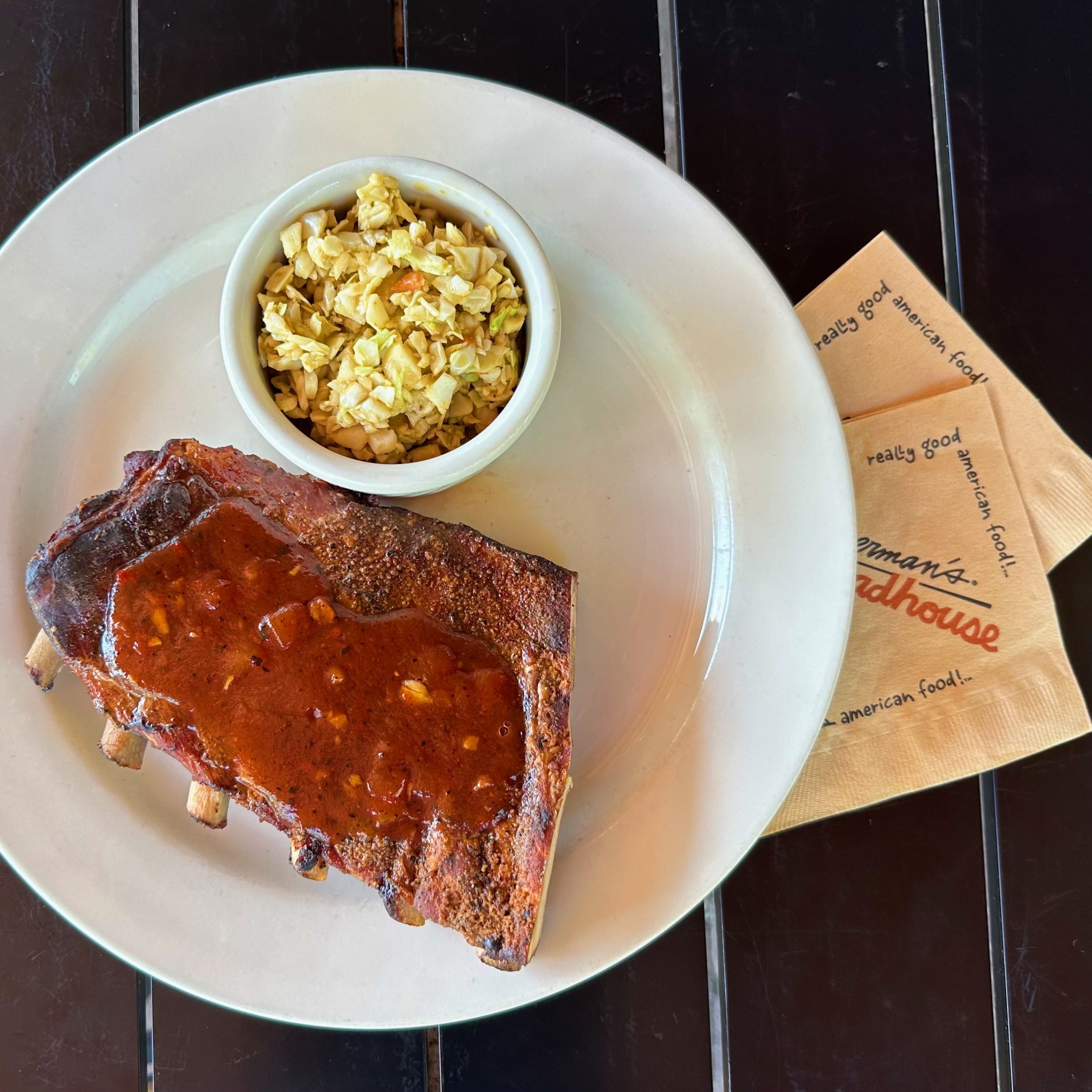 Half a rack of ribs smothered in red bbq sauce.
