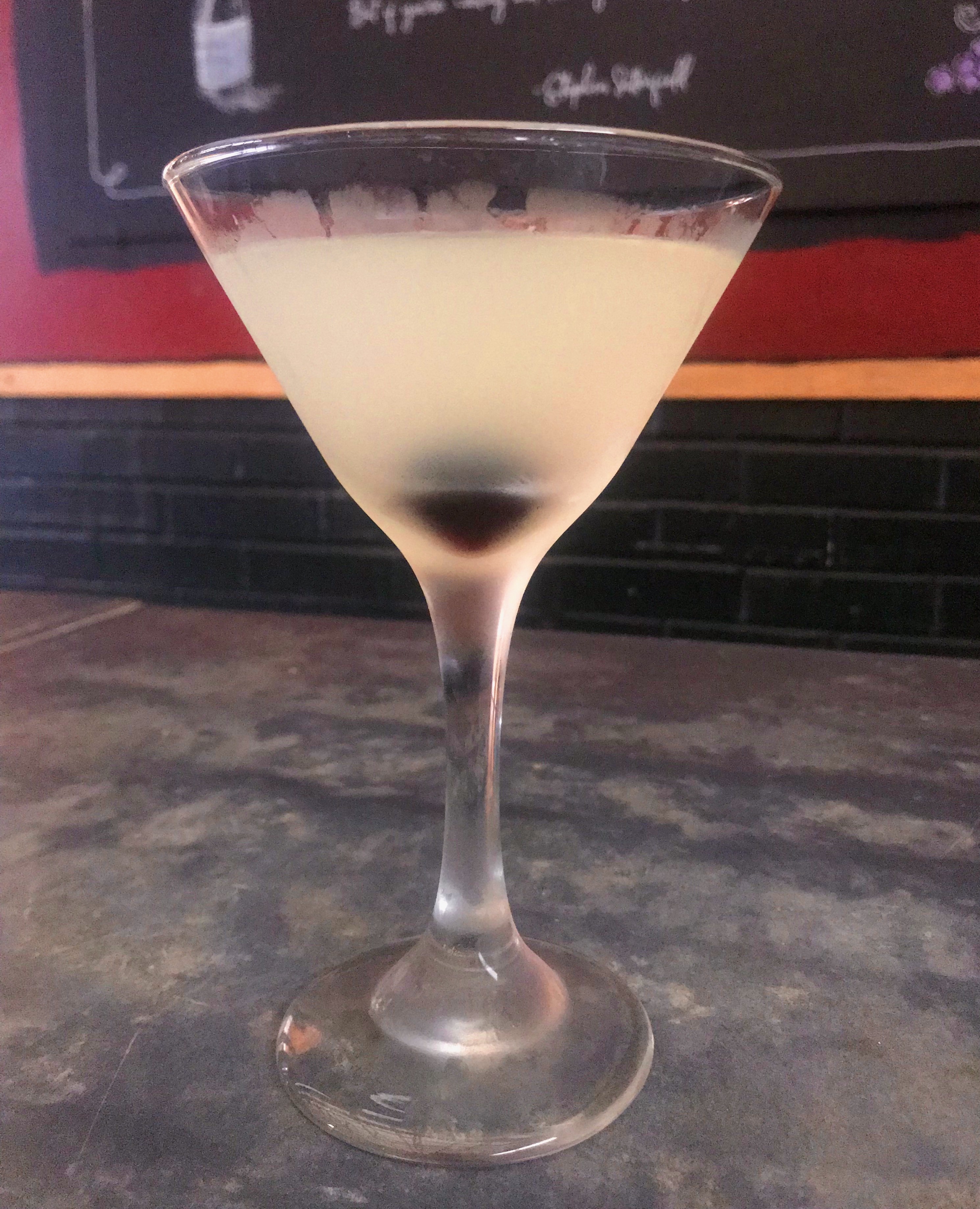 A Corpse Reviver Number 2 cocktail with a Luxardo cherry.