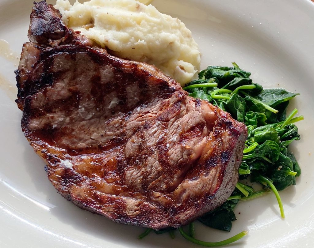 Smoked ribeye with sautéed spinach and mashed potatoes.