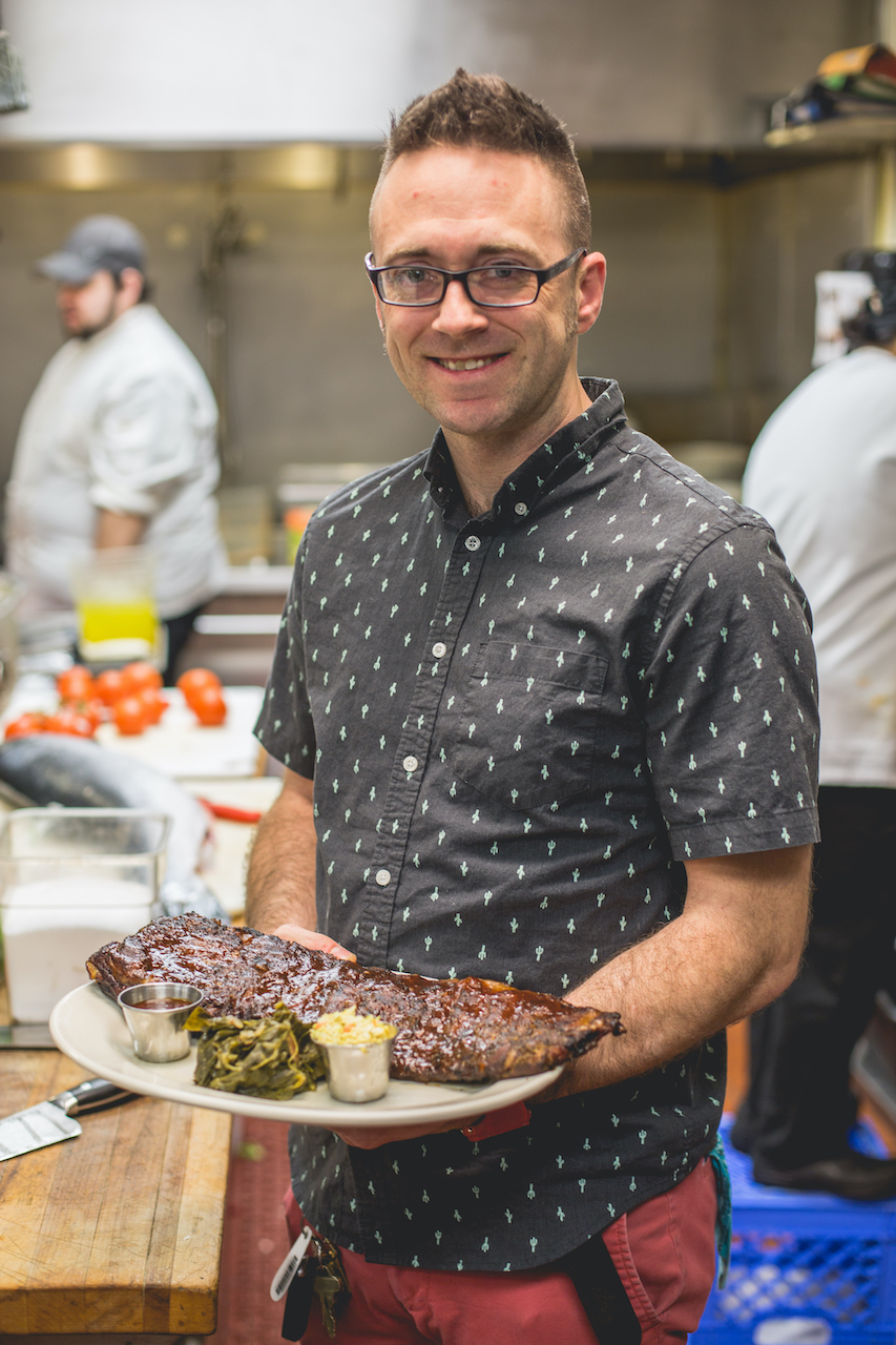 Chef Bob Bennett holding a plate of BBQ at the Roadhouse.