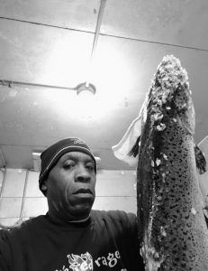A Roadhouse employee, Delbert Williams, holding a large fish.