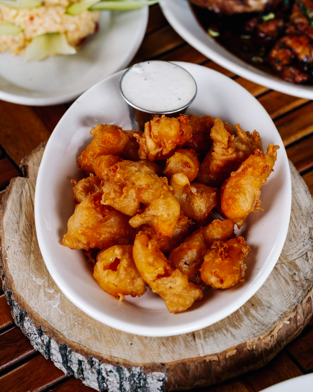 A bowl full of golden fried cheese curds.