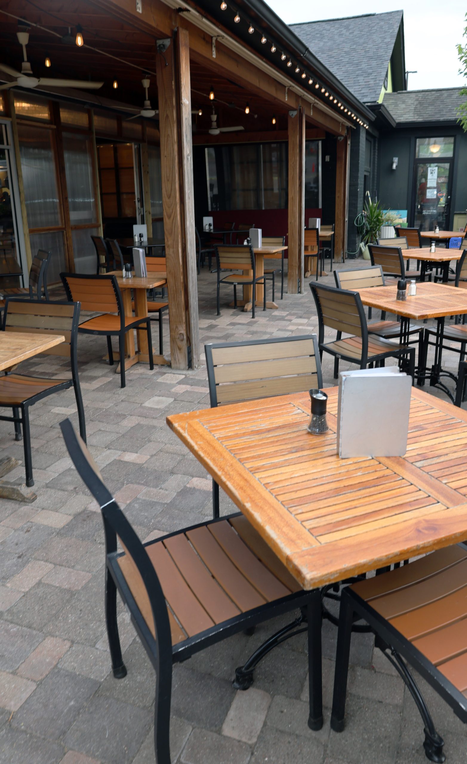 An outer patio set up with wooden dining room tables.