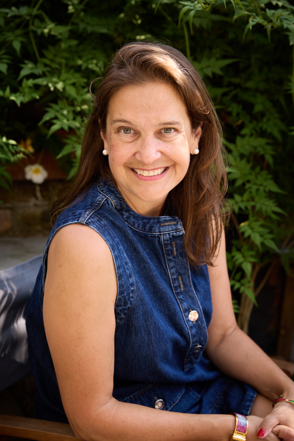 Cookbook author Anna Ansari smiles while sitting a garden.