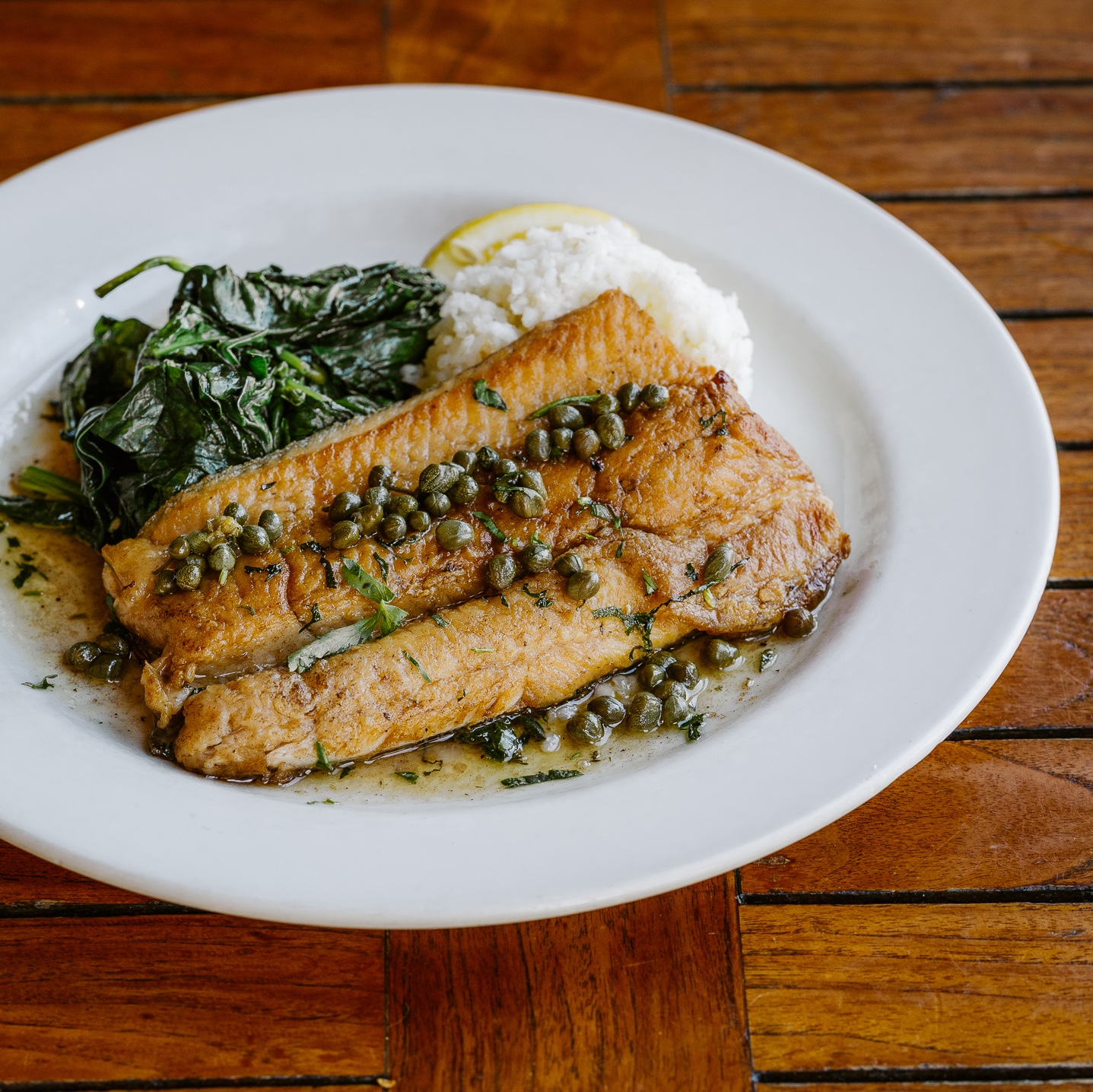 A plate of rainbow trout with browned butter and capers