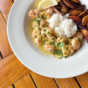A bowl of shrimp on rice with root vegetables