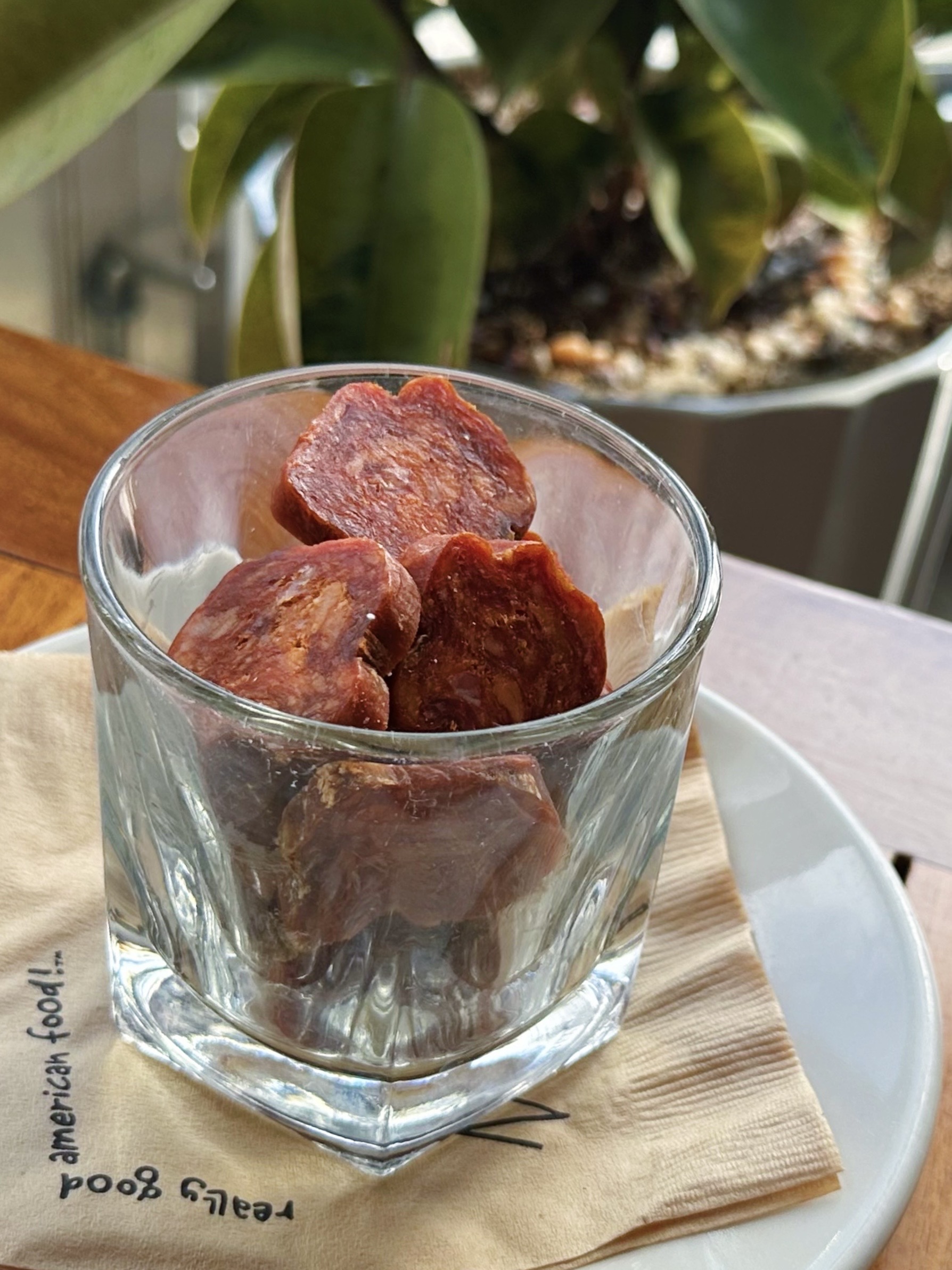 A rocks glass full of sliced dried chorizo