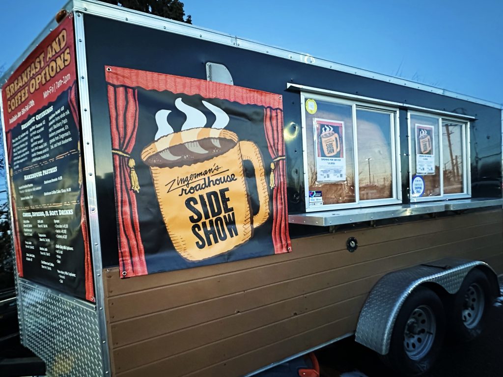 A food and coffee trailer with a banner called the SideShow