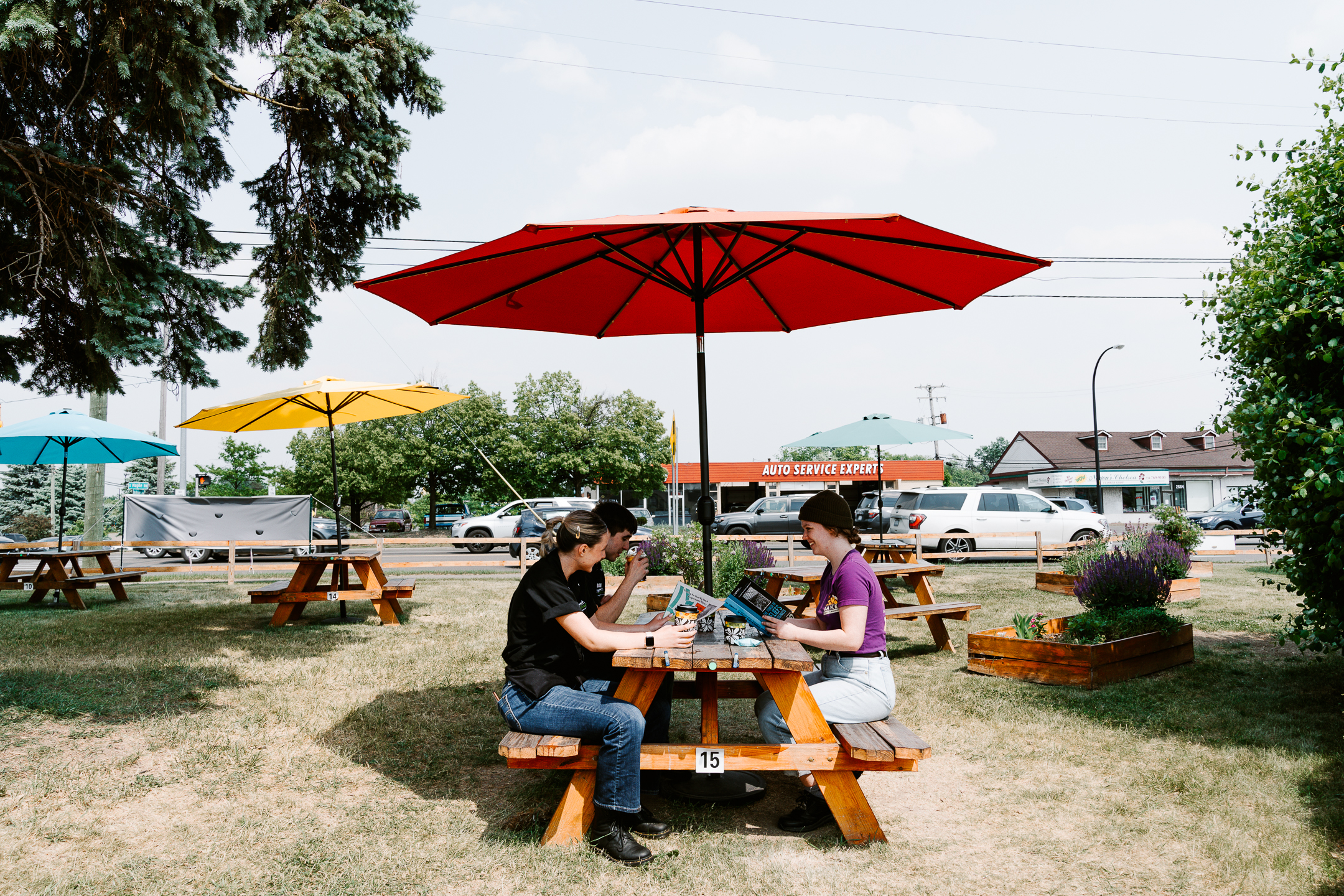 A group of Roadhouse staff meet at a picnic table in the Roadhouse Park