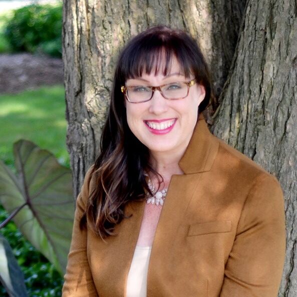 Michelle D Gladieux, smiling in front of a tree.