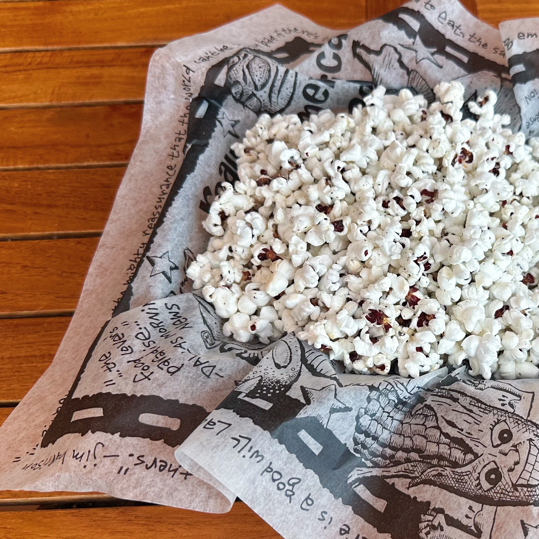 A close-up of a basket of popcorn with herbs and spices.