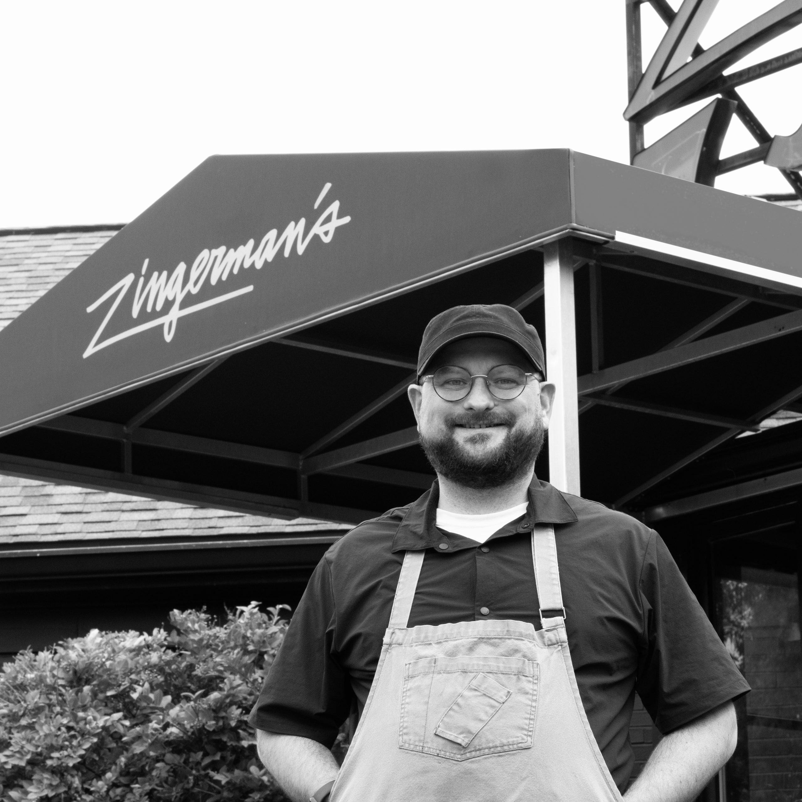 Head Chef Kris McDonough standing in front of Zingerman's Roadhouse, smiling.